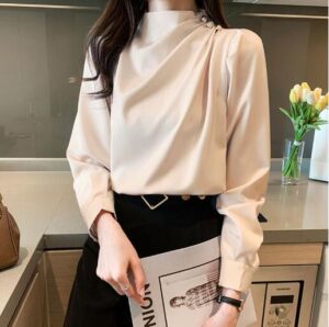 Blouse satin beige avec col haut ornée de finitions dorées