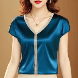 Blouse satin bleue à manches courtes avec finitions dorées