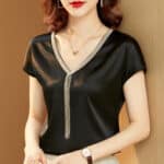 Blouse courte en satin noir avec embellissements dorés