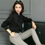 Blouse longue en satin noir avec un nœud.