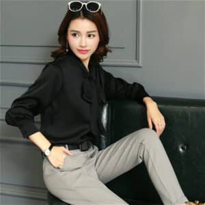 Blouse longue en satin noir avec un nœud.