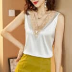 Blouse satinée blanche sans manches ornée de broderies dorées