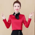 Blouse satin rouge à manches longues ornée d'un nœud noir